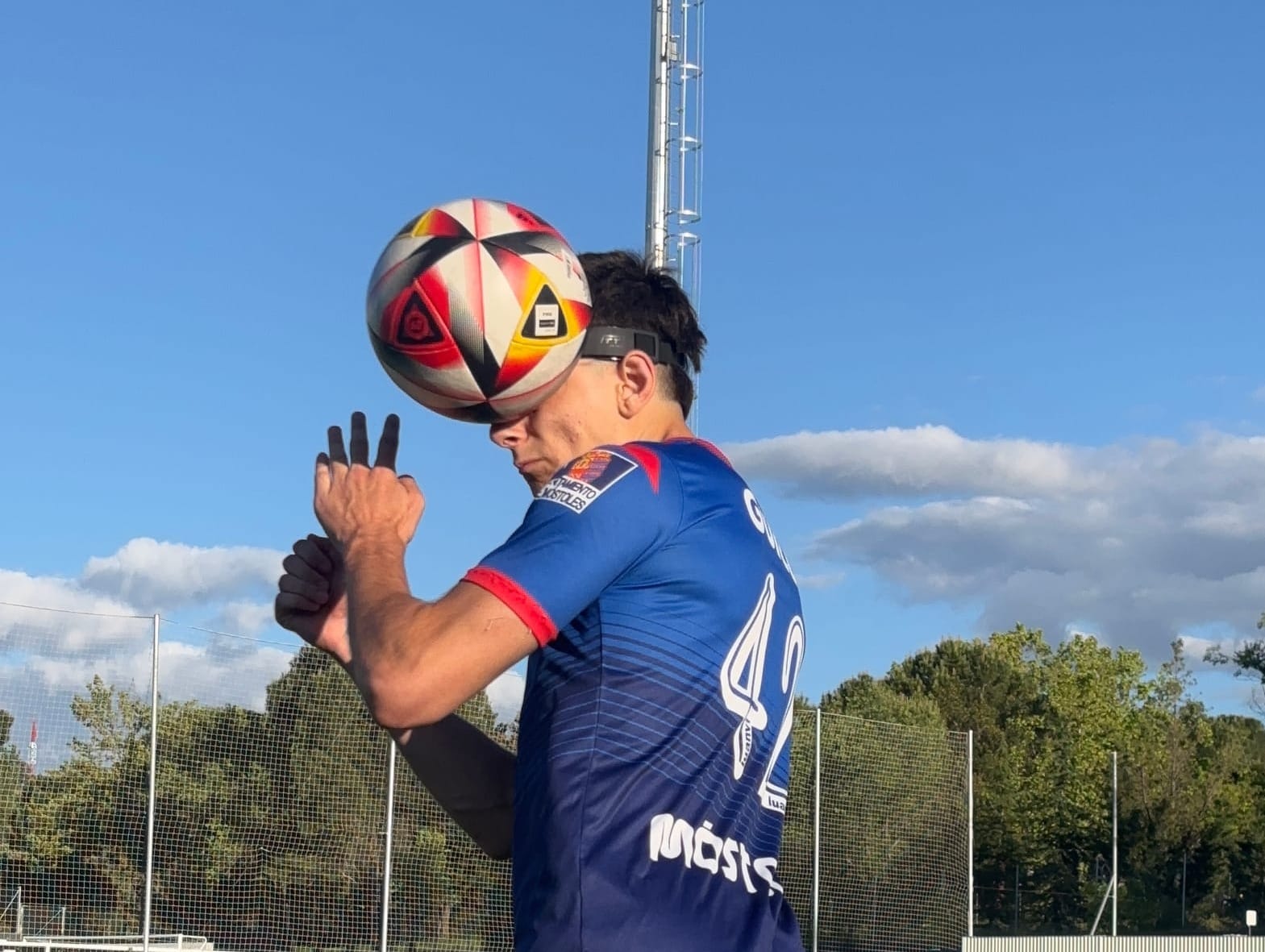 Soccer player wearing concussion helmet heading the ball safely