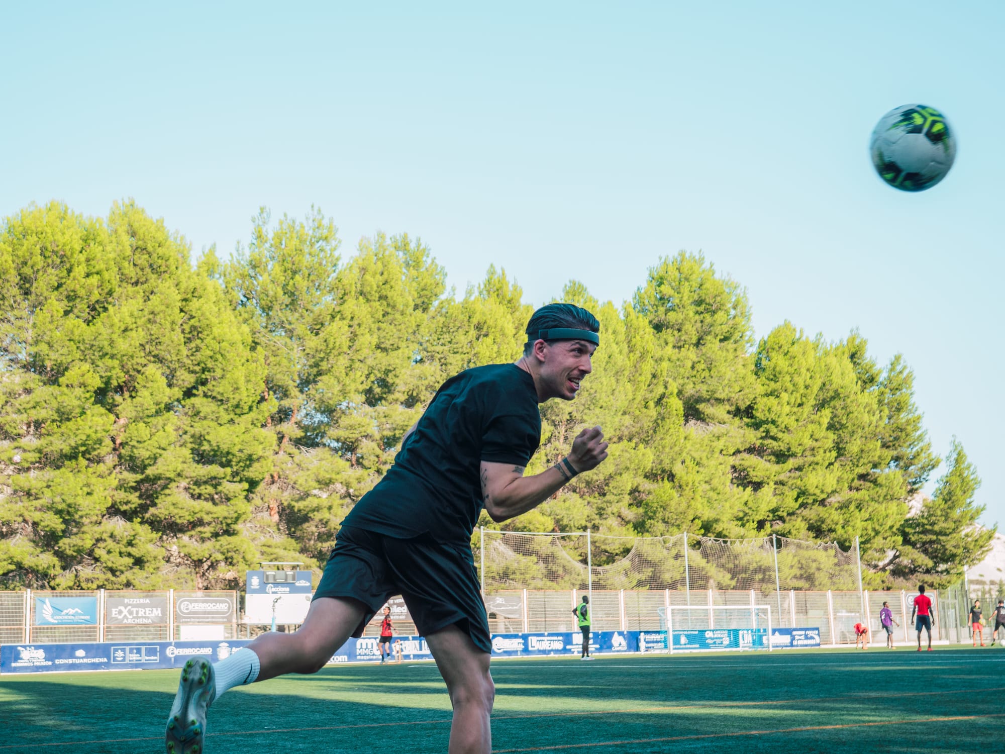 Jugador de fútbol con protección craneal mostrando confianza total durante remate de cabeza decisivo
