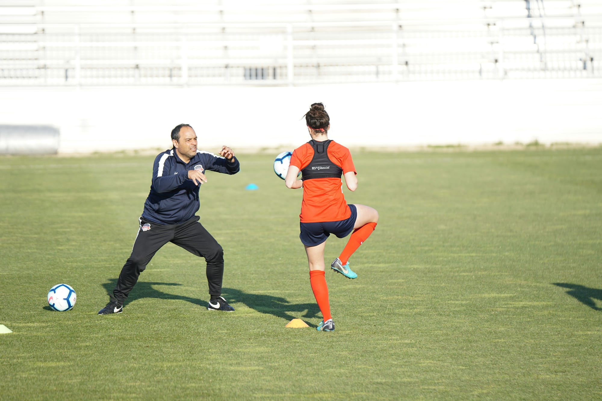 Entrenador personal ayudando a mejorar el control de balón