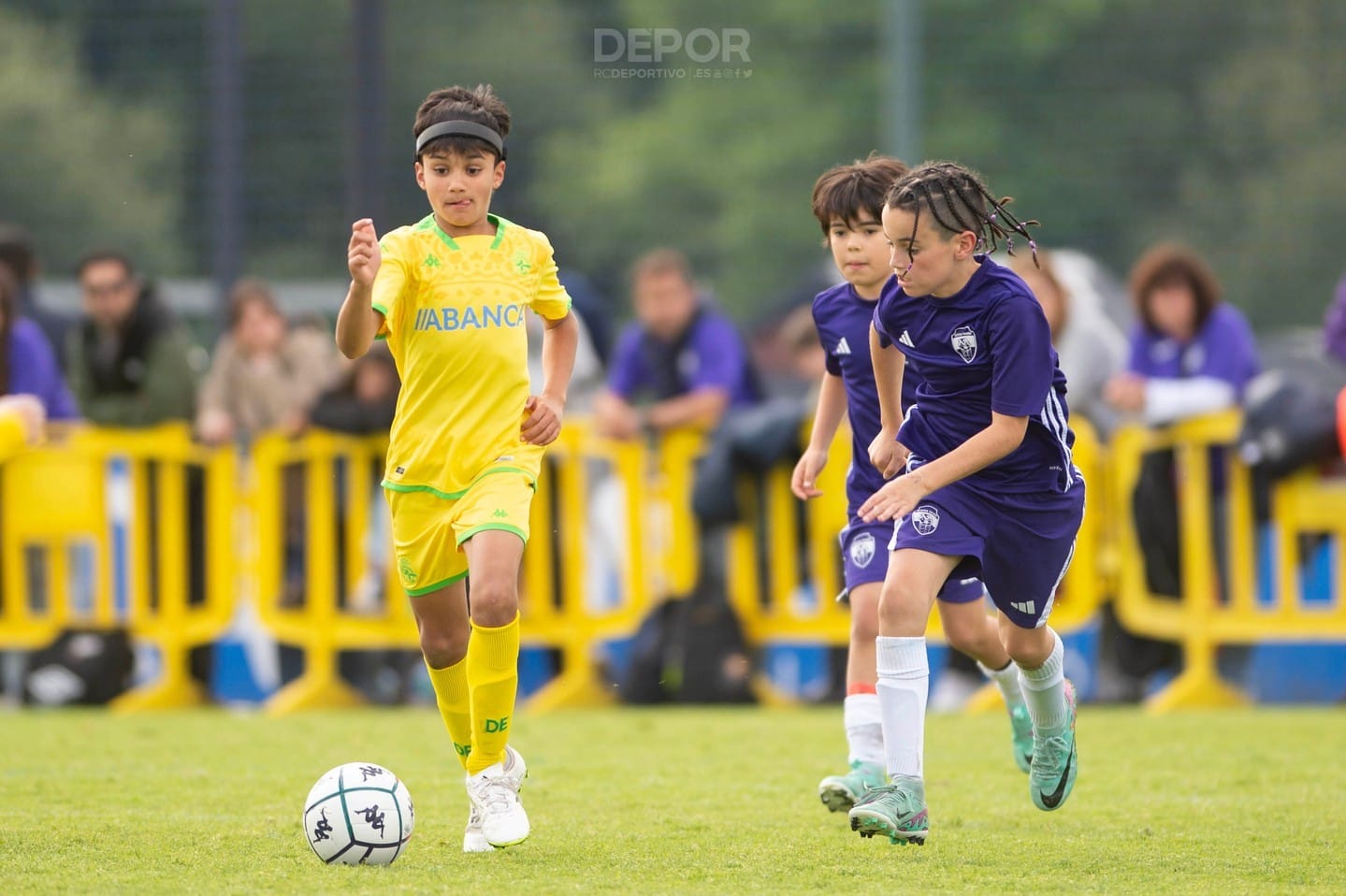 Niño jugando al fútbol motivado y usando un cinta de protección craneal