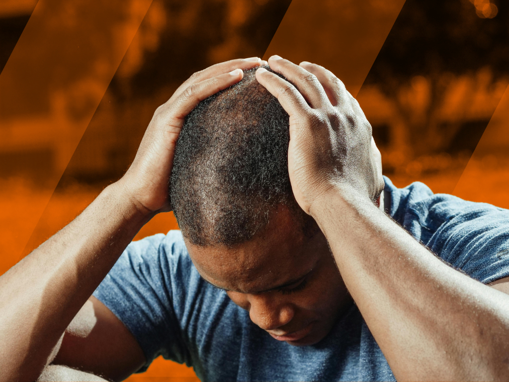 Futbolista sentado en el campo con dolor de cabeza después de jugar un partido de fútbol